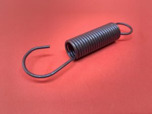 Headlight control spring between pistons